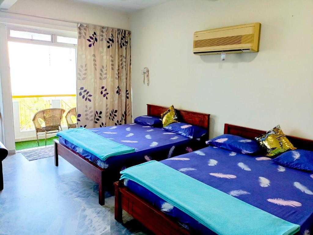 Kampong Tanah Merahseaview studio ocean view resort的一间卧室设有两张床和窗户。