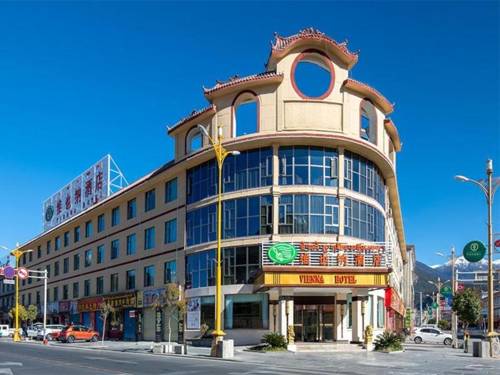 林芝Vienna Hotel Tibet Linzhi Pedestrian Street Hebin Road的城市街道上一座大型建筑,有交通灯