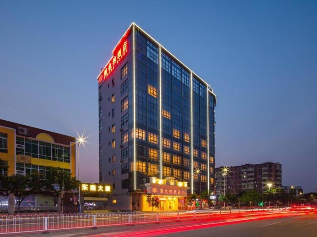 花都Vienna Hotel Guangzhou North Station Huaguoshan Metro Station的一座高大的建筑,上面有标志