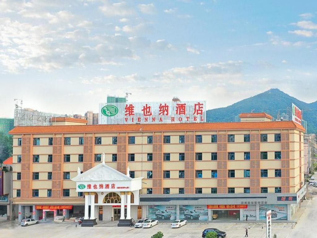 惠东Vienna Hotel Guangdong Huidong Exhibition Center的一座大建筑,上面有标志