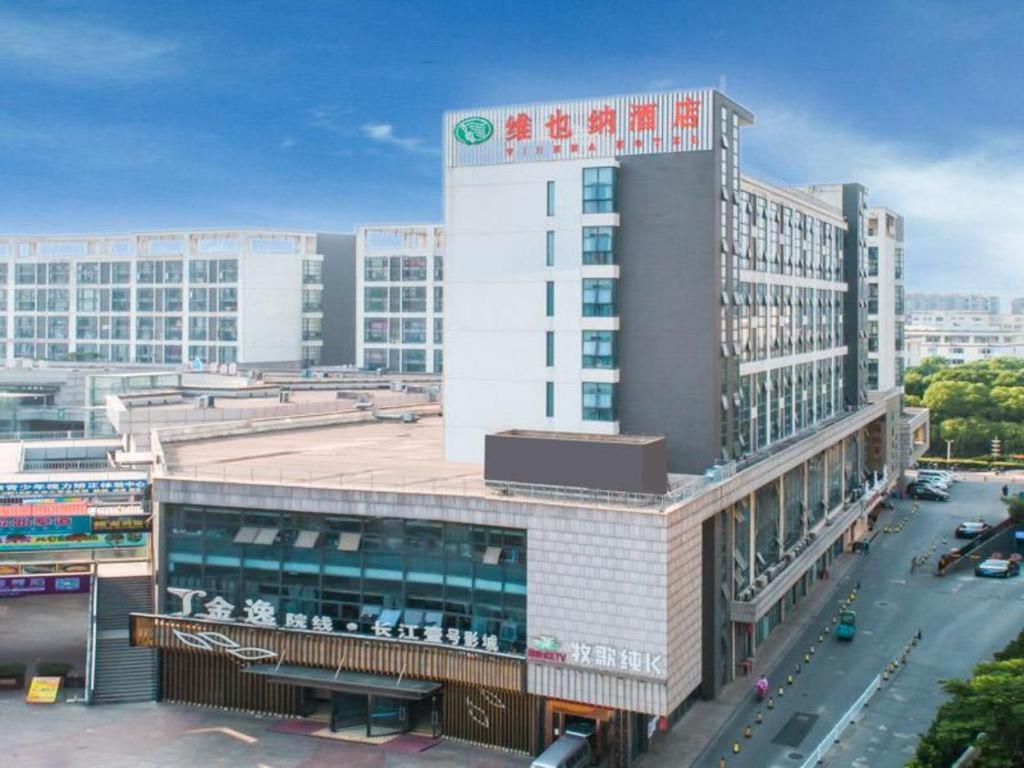 苏州Vienna Hotel Jiangsu Suzhou Mudu 1st Yangtze River University of Science and Technology的一座大建筑,上面有标志