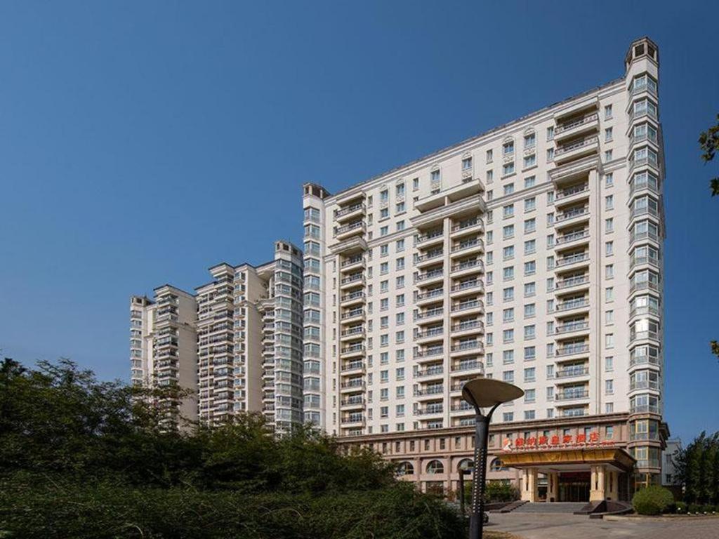 密云Venus Royal Hotel Beijing Miyun的一座白色的大建筑,上面有标志