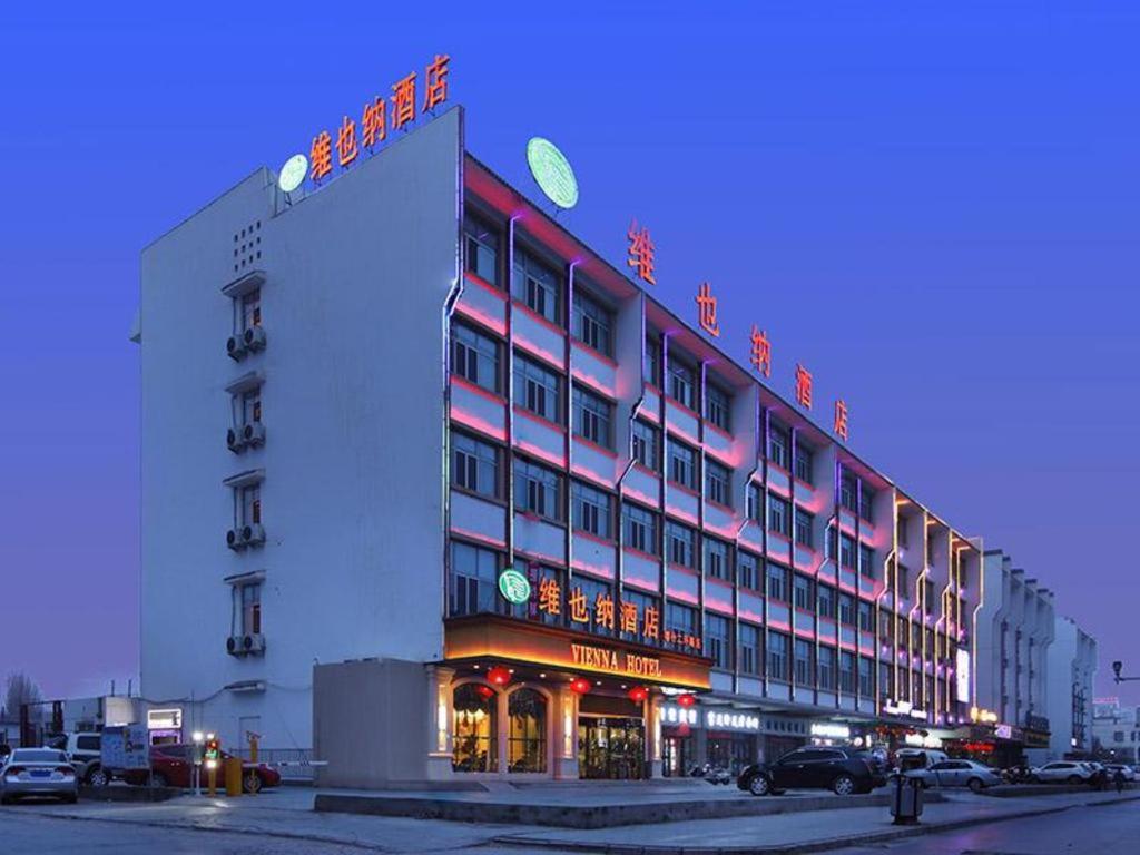 喀什Vienna Hotel Xinjiang Kashgar 2nd Ring Road Food Street的建筑的侧面有标志