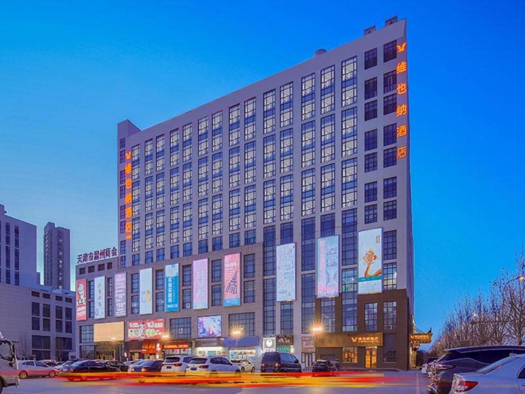 天津Vienna Hotel Tianjin Jinzhong Street的一座大建筑,上面有很多标志