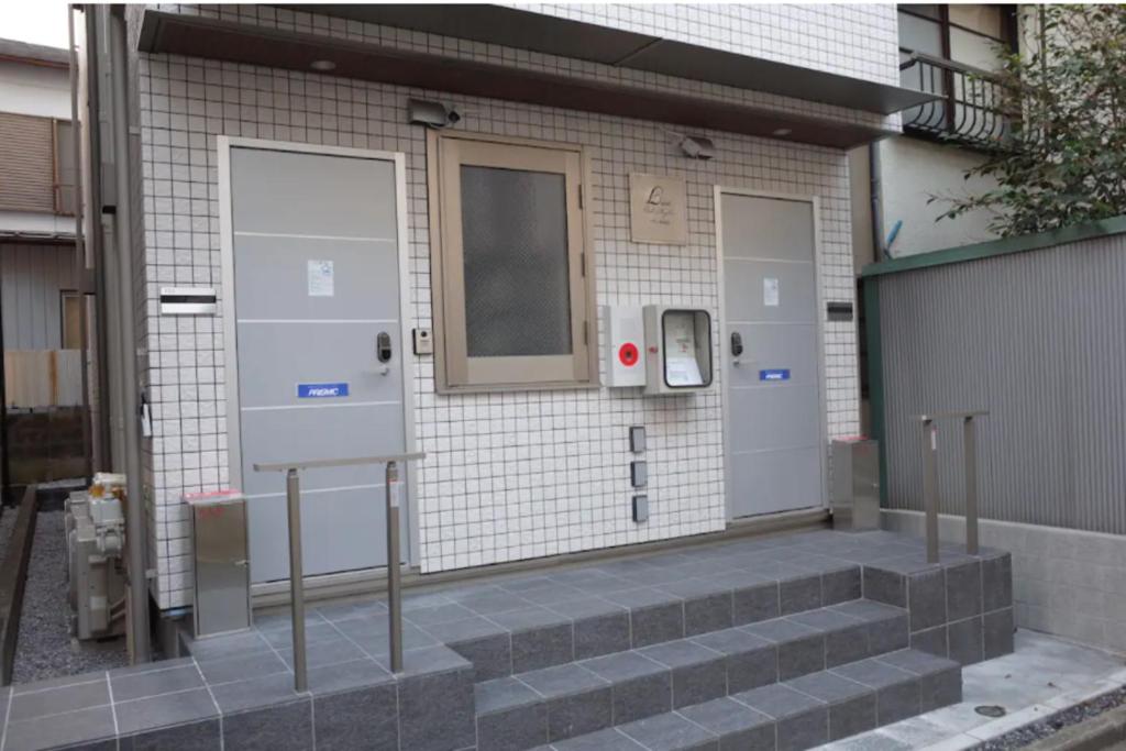 东京Lien Nishi Shinjuku的建筑上设有门和楼梯