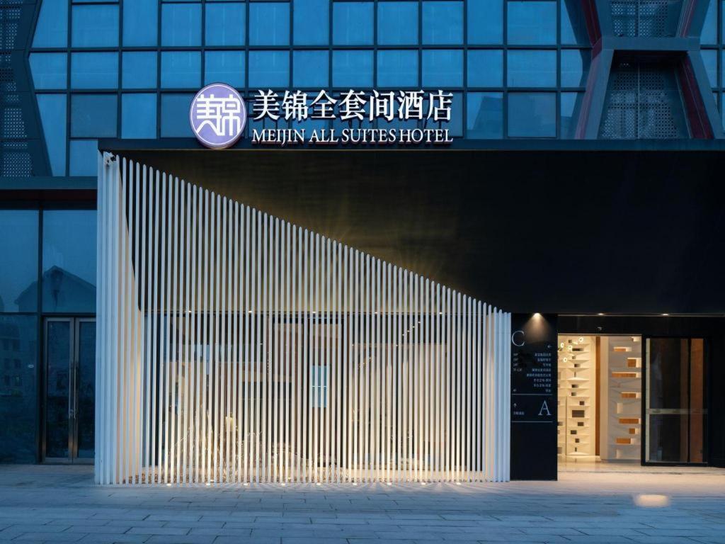 苏州Meijin All Suites Hotel Suzhou的上面有标志的建筑