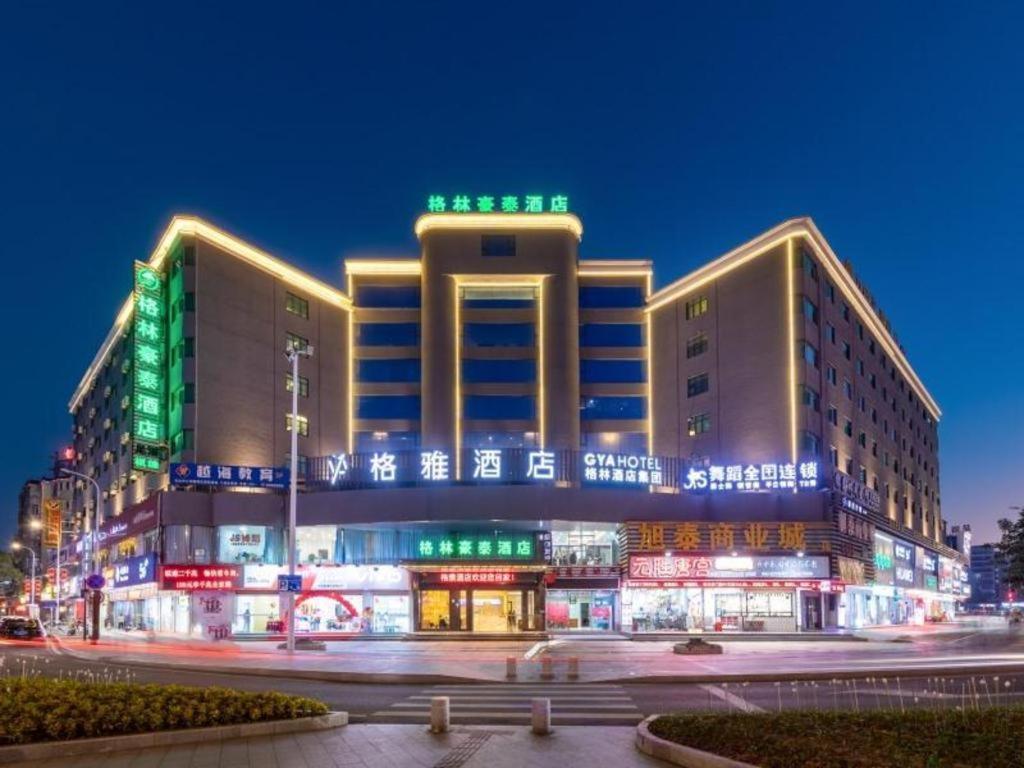 珠海Gya Hotel Zhuhai International Airport New Town的一座绿白灯的大建筑