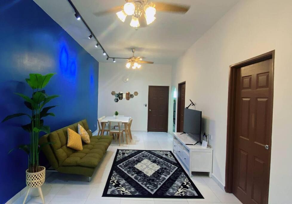 斯里曼绒R&R Manjung Guest House at Pangsapuri Samudera的客厅配有绿色沙发和电视