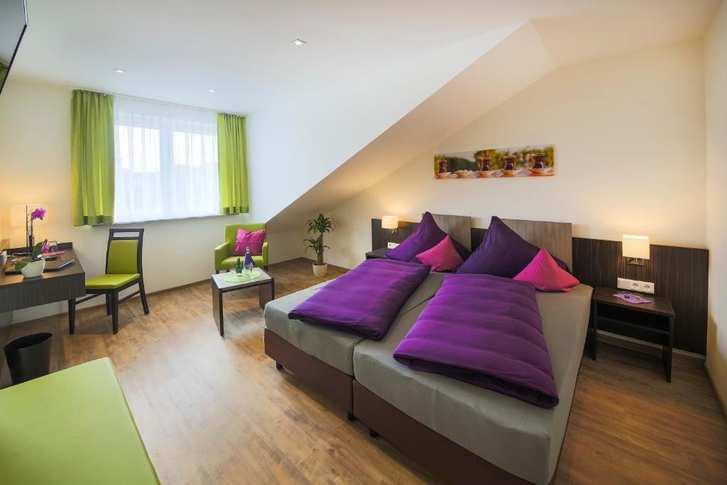 腓特烈港Hotel Gästehaus Stock Zimmer Teekännle的一间卧室配有一张带紫色枕头的大床