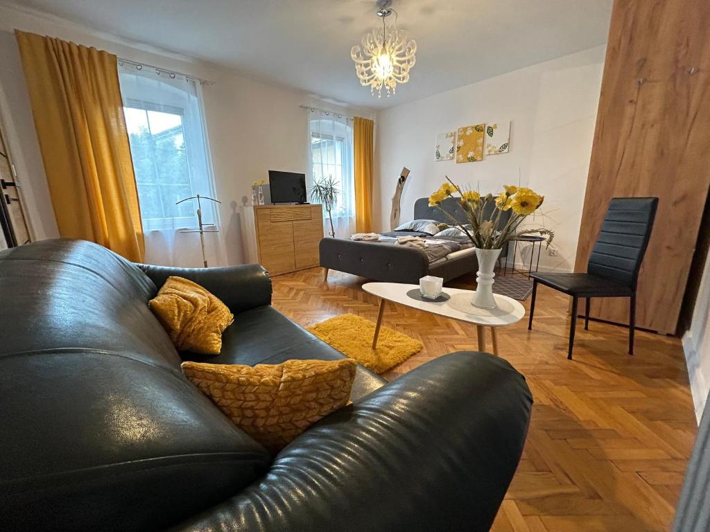 弗罗茨瓦夫ARTHOME的客厅配有黑色真皮沙发和桌子