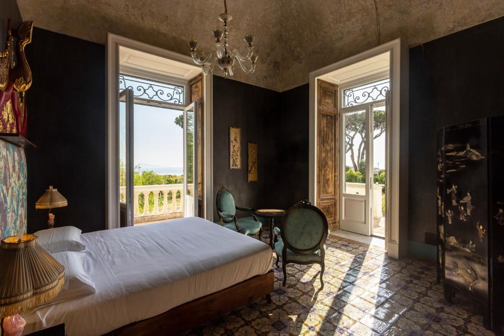 托雷德尔格雷科Villa De Cillis Carafa的卧室配有床、桌子和窗户。