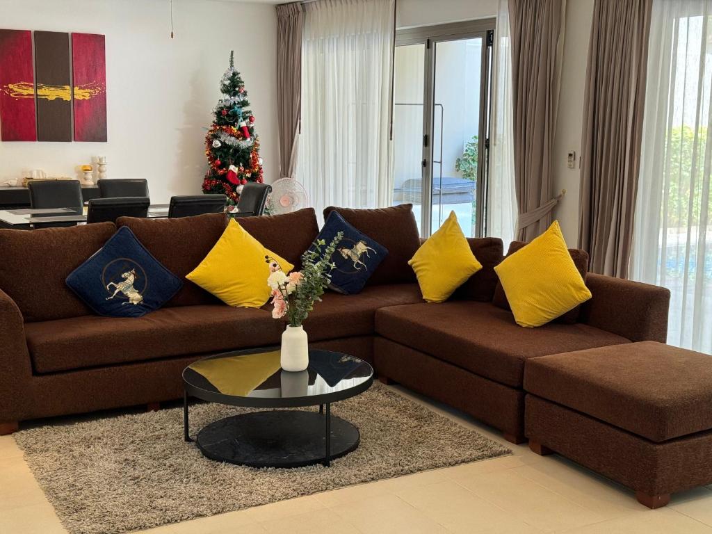 邦涛海滩Wonderful villa Harmony BangTao beach的客厅配有棕色的沙发和圣诞树