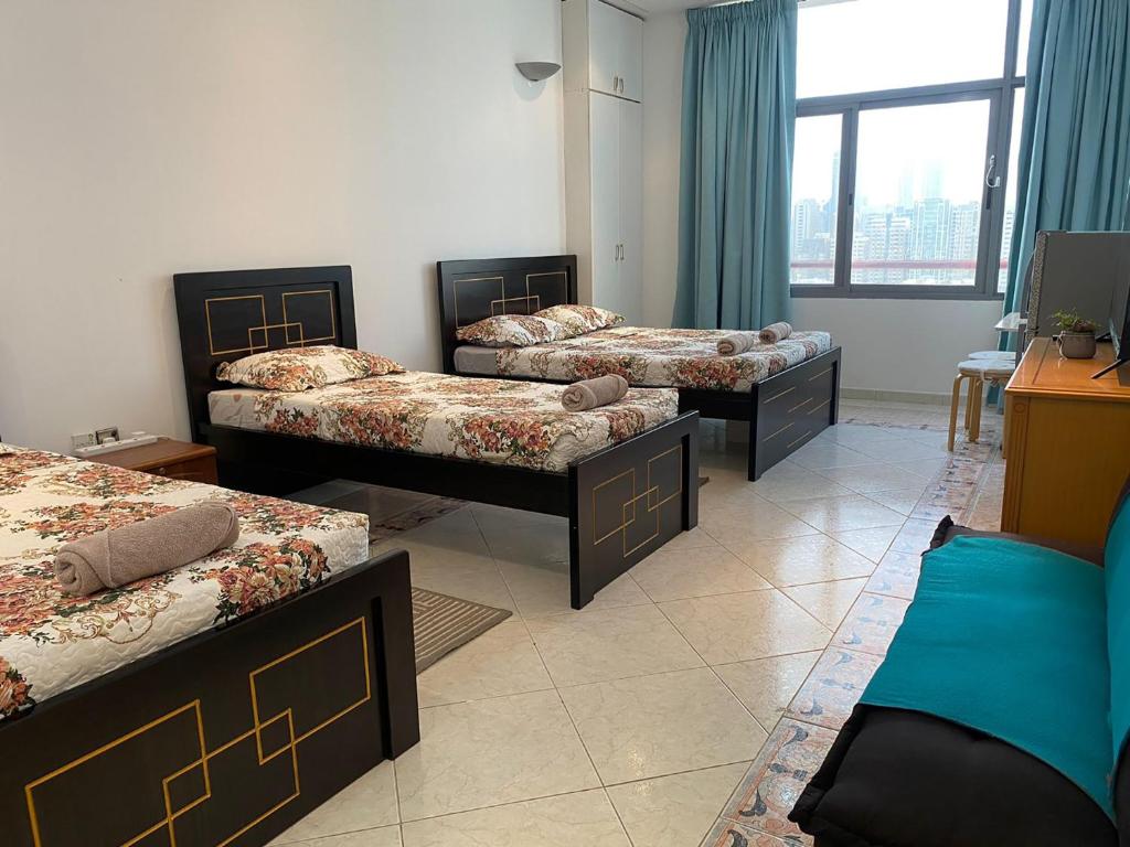 阿布扎比J & F Homestay - Abu Dhabi的带大窗户的客房内的三张床