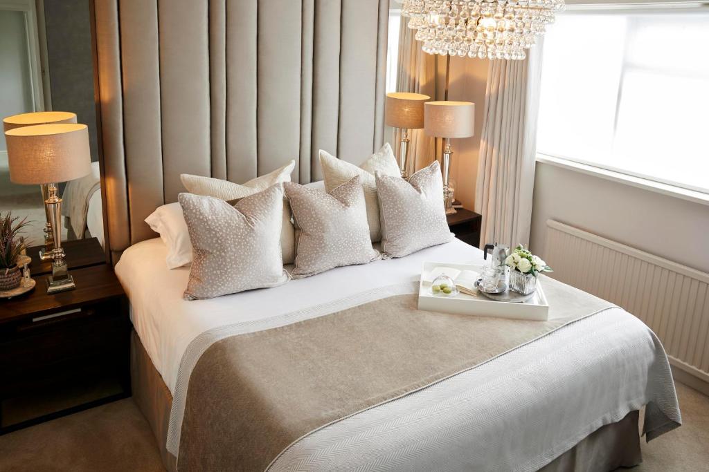 KelambākkamVishnu Living rooms and villas的卧室配有一张带吊灯的大型白色床。