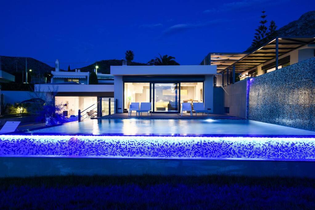 苏尼翁Luxury Beachfront Villa Selenia Gold in Sounio的夜间带游泳池的别墅