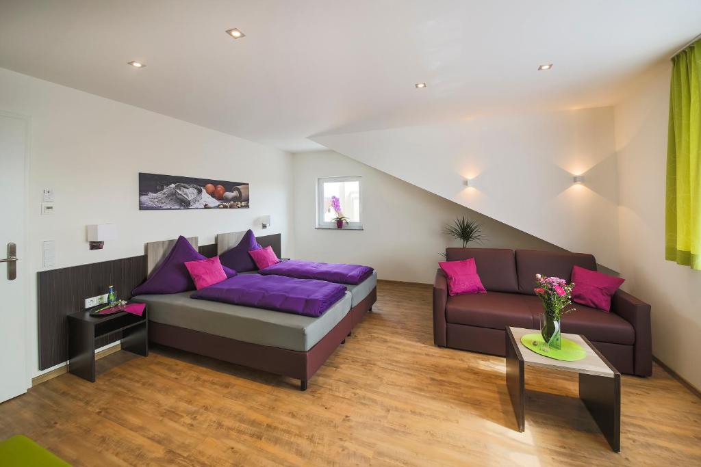 腓特烈港Hotel Stock Bäckerstüble的客厅配有沙发和紫色枕头
