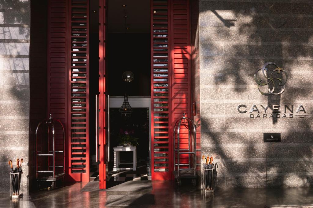 加拉加斯卡耶那-加拉加斯酒店的一间在墙上设有红色百叶窗的房间,设有楼梯
