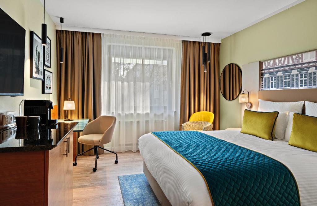 埃斯林根Leonardo Hotel Esslingen的配有一张床和一张书桌的酒店客房