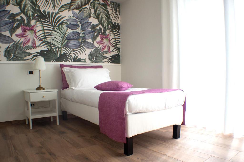 PontiniaIl Piccolo Eden的一间卧室配有一张带紫色毯子的床
