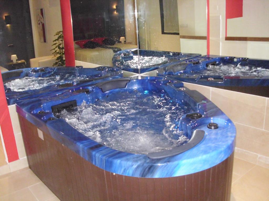 Cabañas de PolendosCasa Rural con Jacuzzi La Dulce的浴室内设有一个蓝色的大浴缸