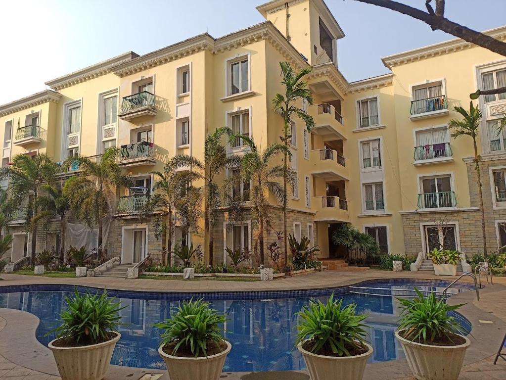 GoaAsta by Avim的公寓大楼设有游泳池和棕榈树