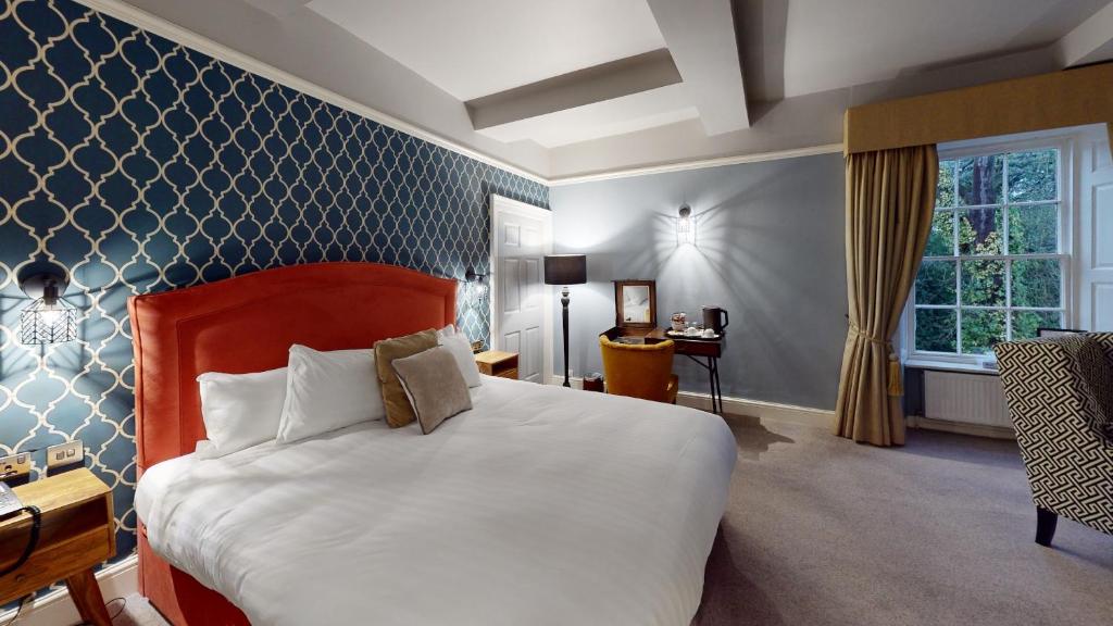 唐克斯特欧斯敦霍尔酒店的酒店客房设有一张大床和一张书桌。