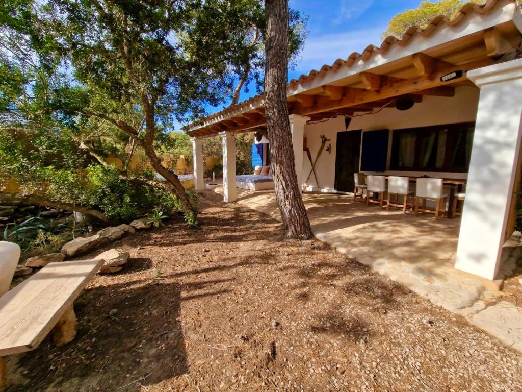 埃斯卡洛Casa Migjorn, immersa nella natura a pochi passi dal mare的户外庭院设有长凳和树