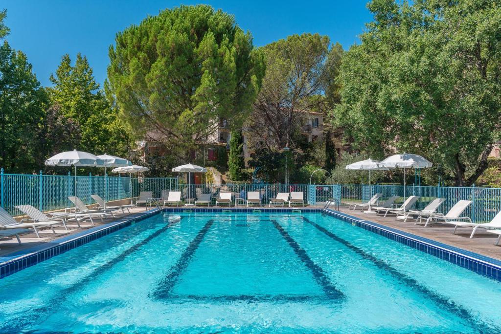 格雷乌莱班勒马斯克莱梅丽尔酒店的一个带椅子和遮阳伞的游泳池
