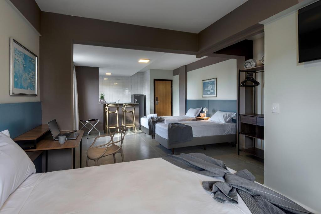 乌贝兰迪亚Lym Flat Hotel的酒店客房配有两张床和一张书桌