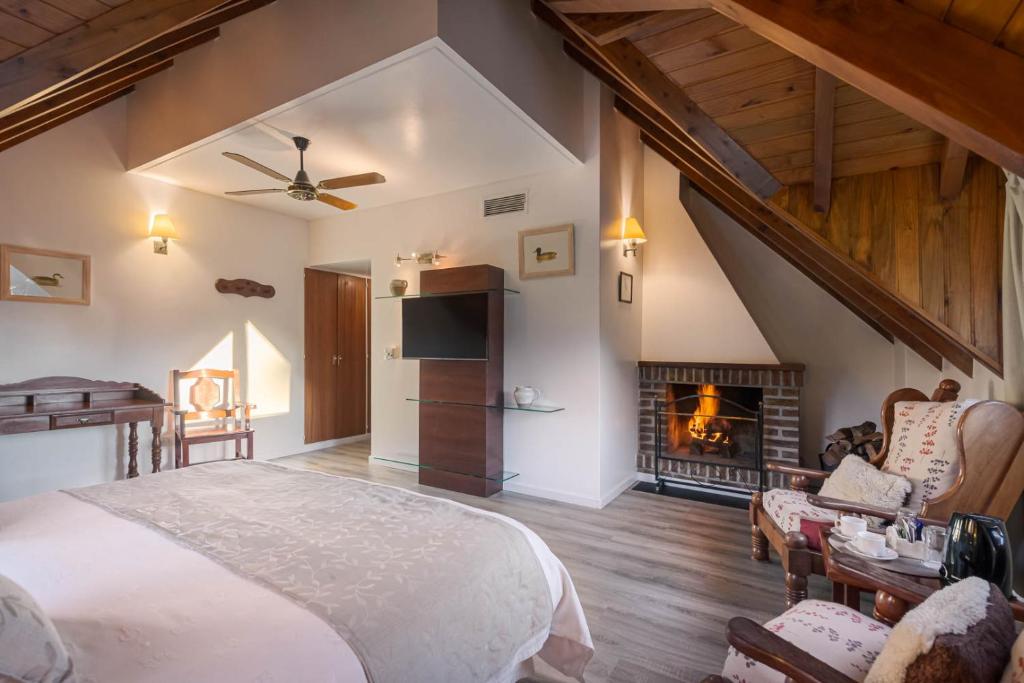 圣马丁德洛斯夏特勒酒店的一间卧室配有一张床和一个壁炉