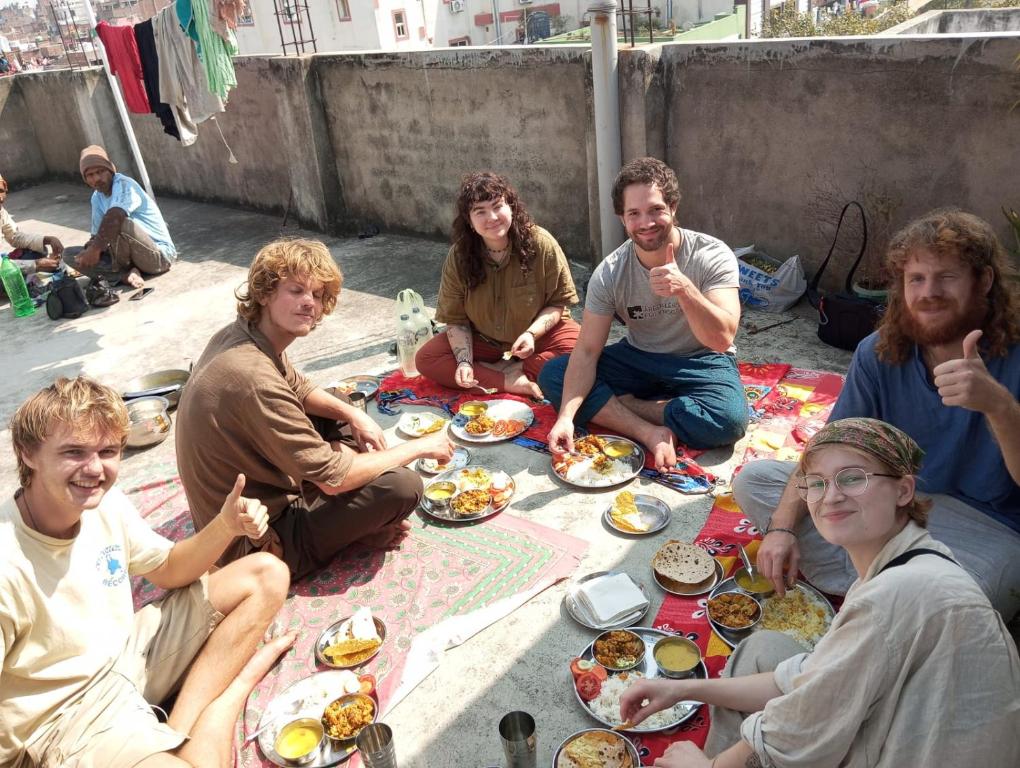 加雅Darbar Homestay的一群坐在地面上吃食物的人