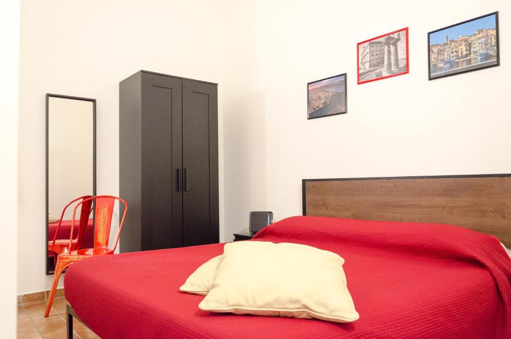 塔兰托Downtown Lodge Museum的一间卧室配有红色的床和黑色橱柜