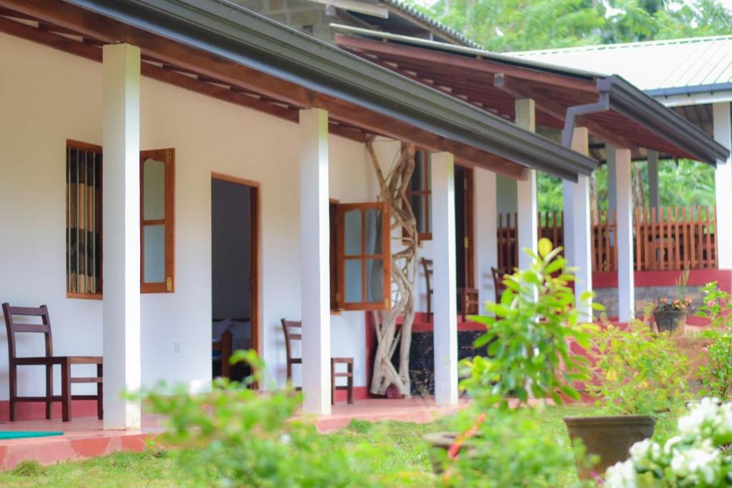 代尼耶耶Sinharaja Forest Lodge的院子内带桌椅的房子