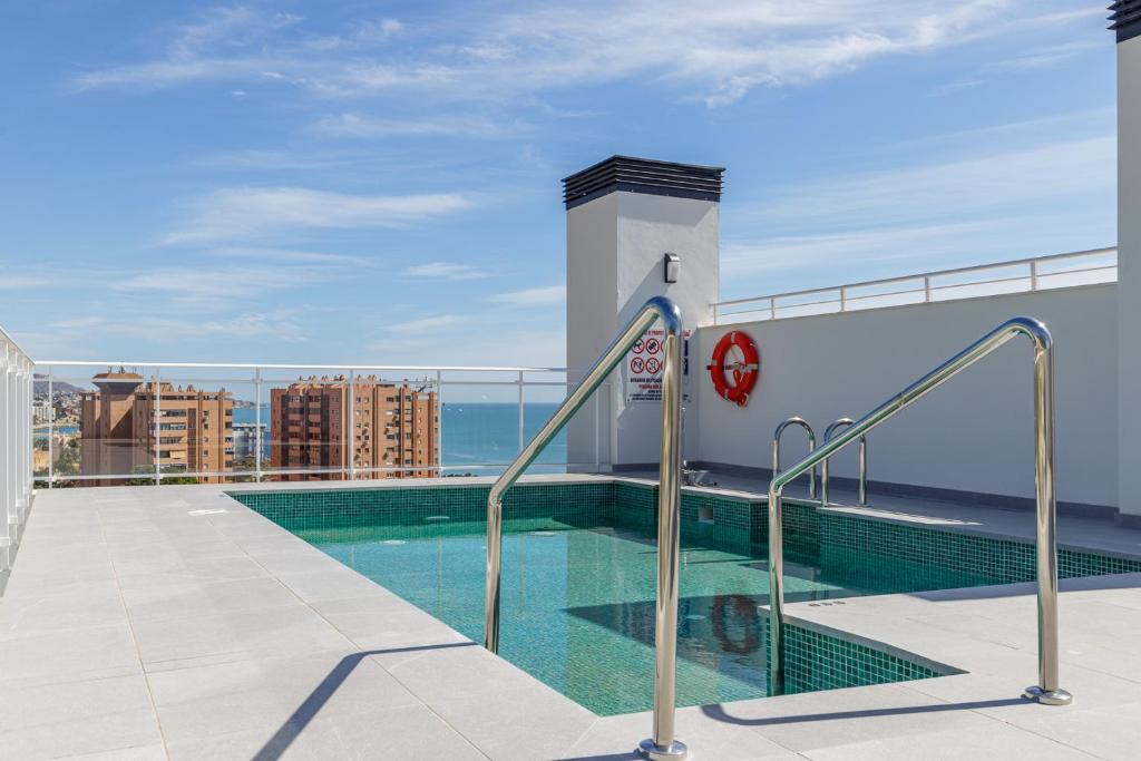 马拉加Malagueta Miramar with Shared Pool by Caleta Homes的建筑物屋顶上的游泳池