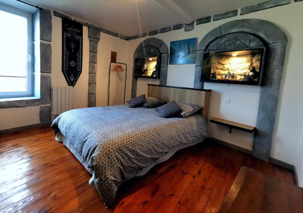 VertaizonSuite privative Le seigneur des anneaux Gondor的一间卧室设有一张带壁炉的床,铺有木地板。