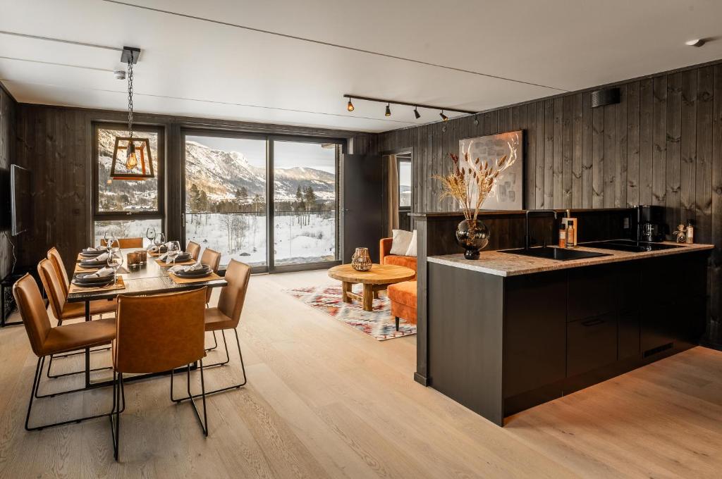 海姆瑟达尔Helt ny leilighet i Hemsedal, rett ved Fyri Resort - Ski inn - Ski out的厨房以及带桌椅的用餐室。
