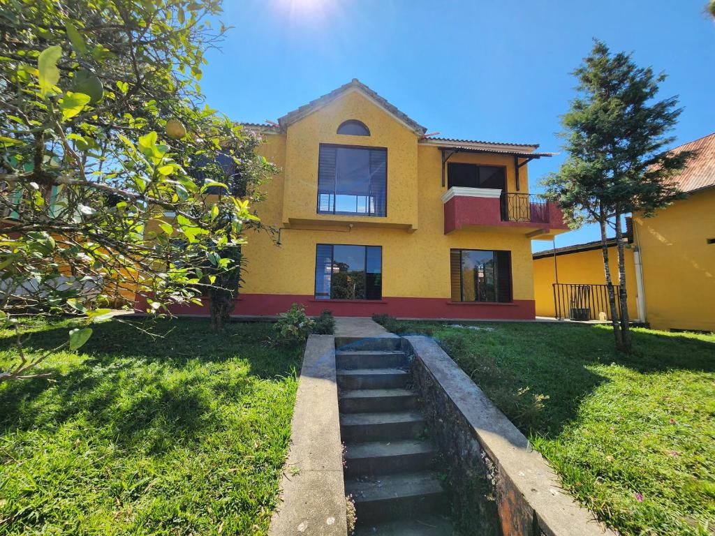 San Pedro CarcháLas Flores的前面有楼梯的黄色房子