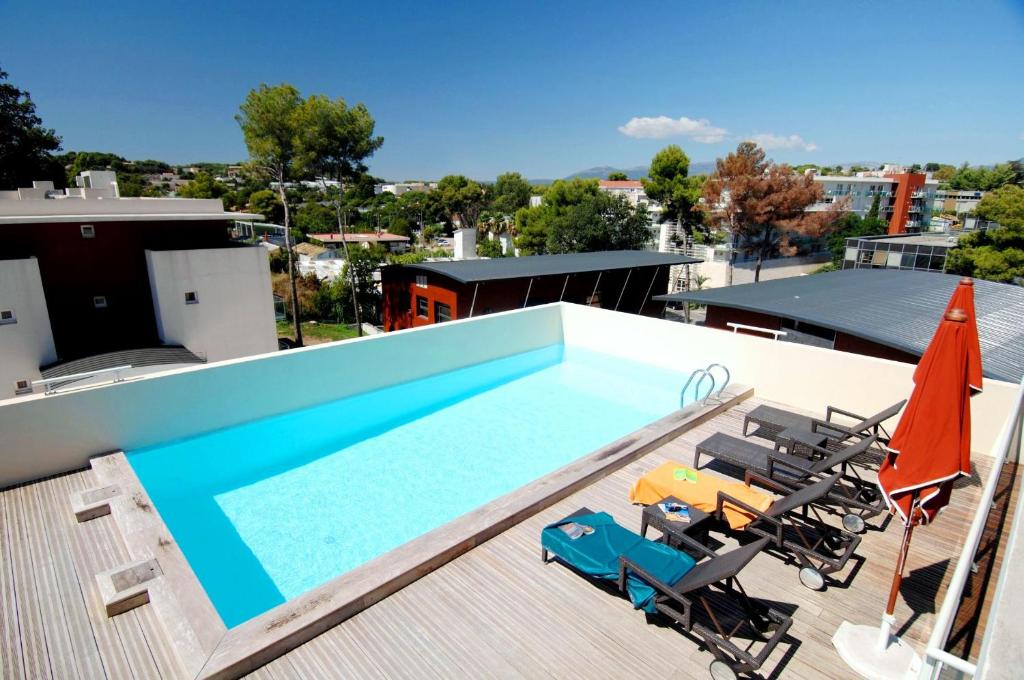 昂蒂布昂蒂布奥林普奥德利斯市公寓式酒店的屋顶上带椅子和遮阳伞的游泳池