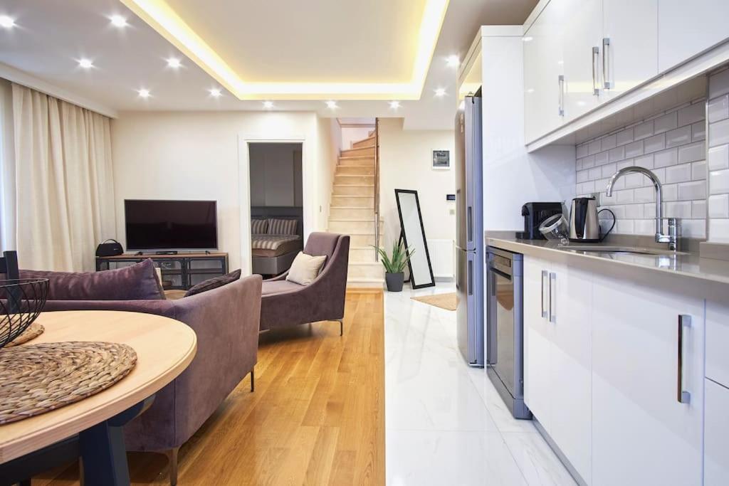 伊斯坦布尔Privat 3 Bedroom Duplex Apartment at Ulus Beşiktaş的厨房以及带沙发和桌子的客厅。