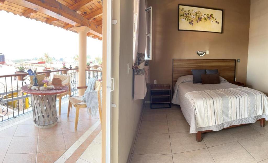 马萨米特拉埃尔莱纳多酒店的一间卧室配有一张床,阳台配有桌子