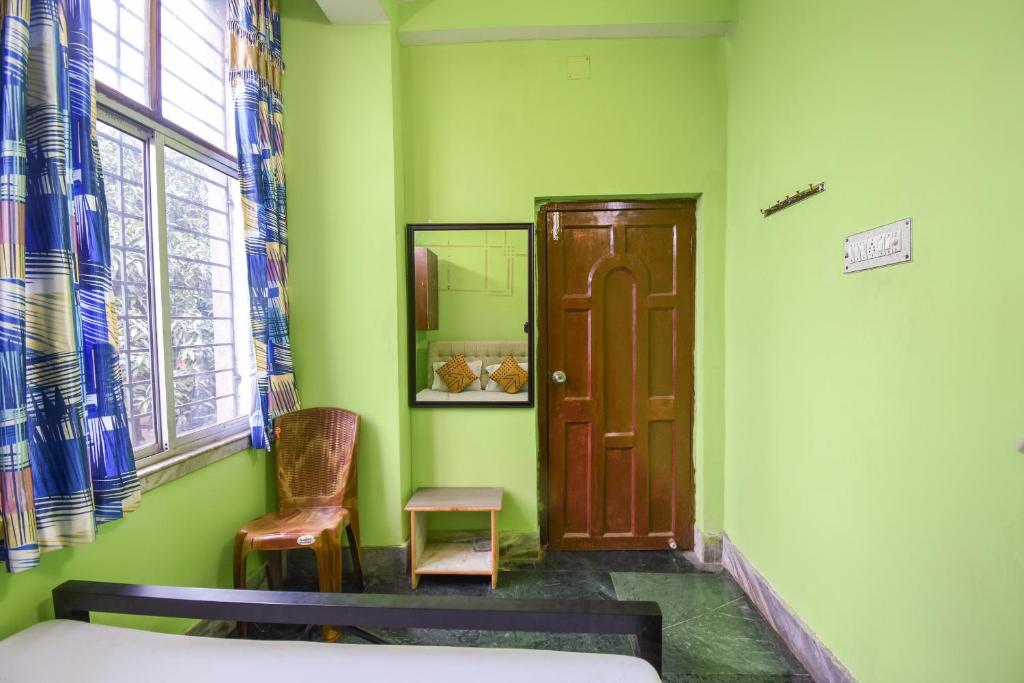 NagarbazarOYO Petals Residency的一间设有床、门和椅子的房间