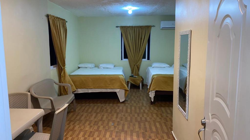 圣塔芭芭拉-山美纳Paraíso de Rojas hotel的客房设有两张床和窗户。