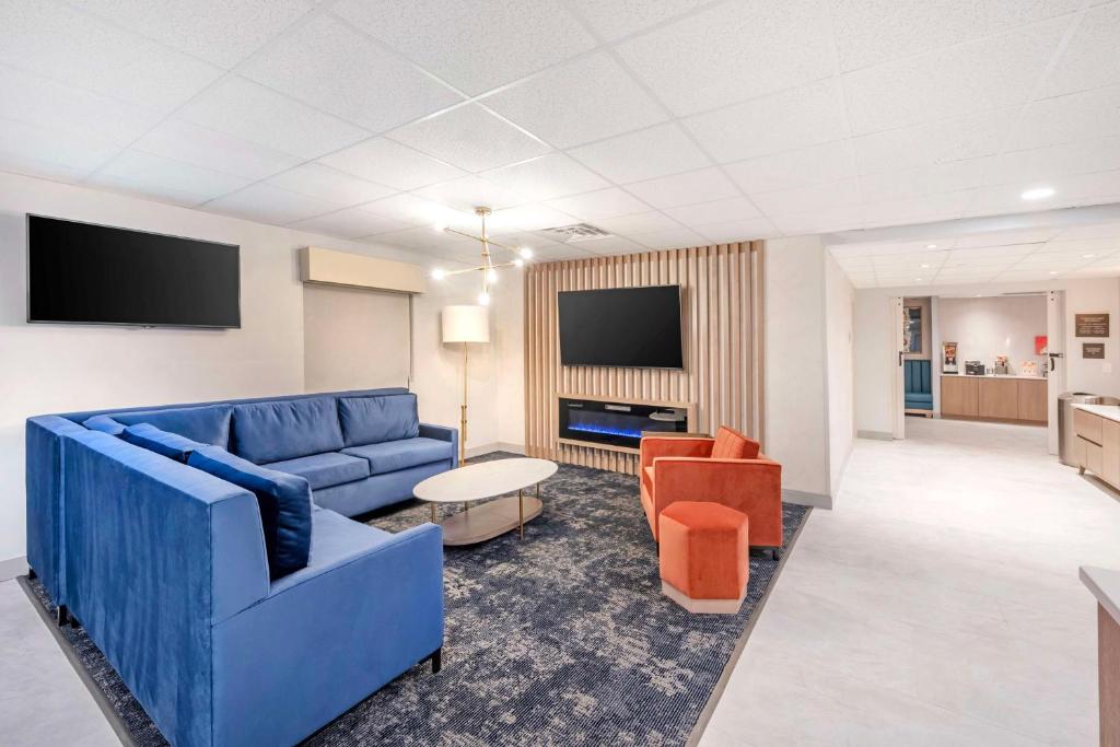 阿什兰河城贝斯特韦斯特酒店的客厅配有蓝色的沙发和橙色椅子
