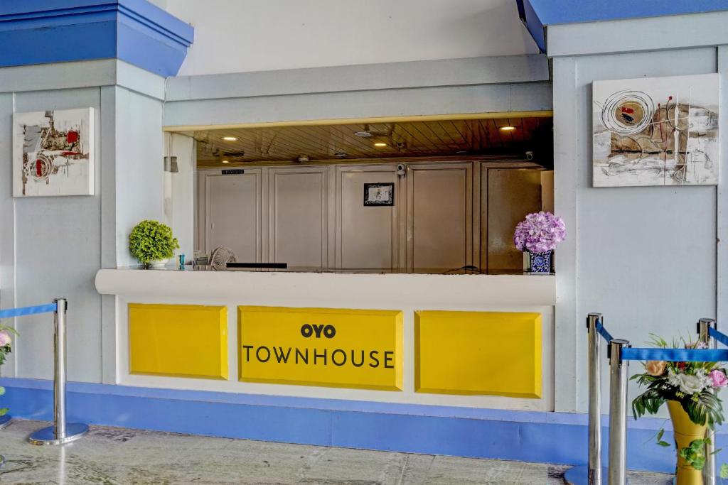 孟买Townhouse Royal Palms Hotel - Lily的厨房里的一个黄色柜台,上面有女狼的标志