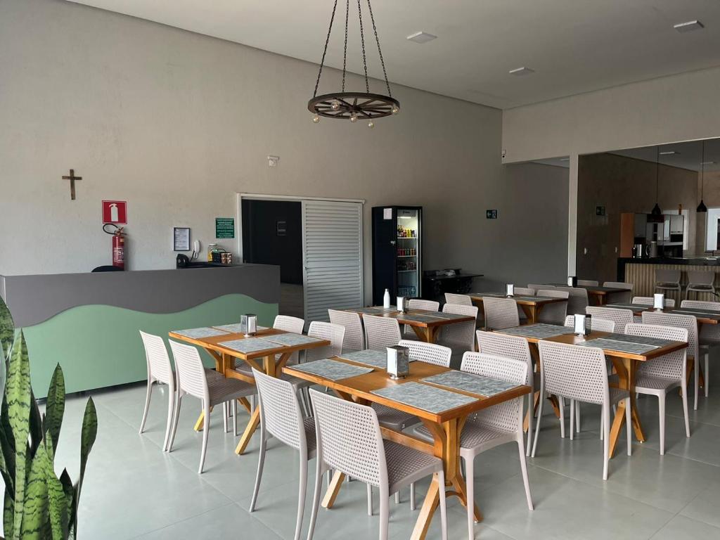 萨利纳斯HOTEL XANGRILÁ的用餐室配有木桌和白色椅子