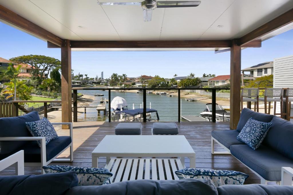 黄金海岸Magnificent 4-Bed Waterfront With Pool & Views的天井配有沙发和桌子,享有水景