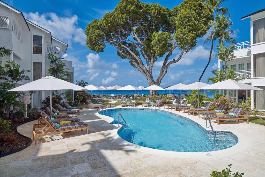 圣詹姆斯Treasure Beach by Elegant Hotels - All-Inclusive, Adults Only的度假村的游泳池配有躺椅和遮阳伞