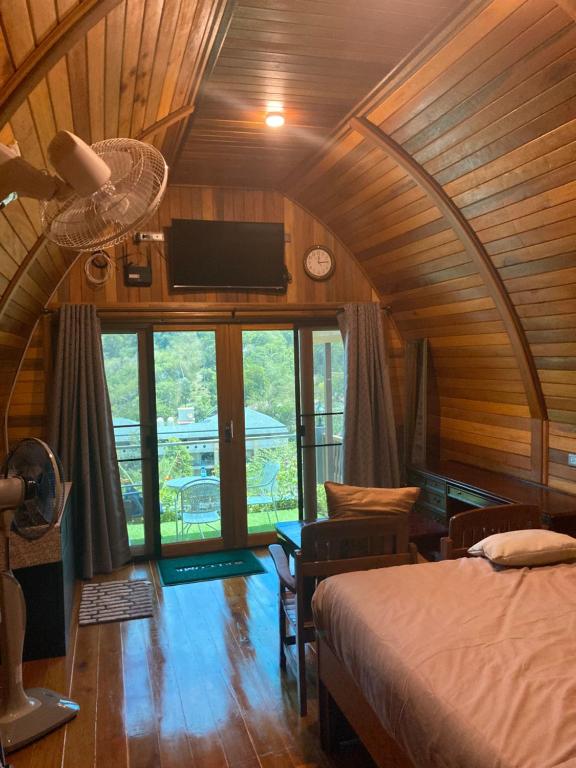 拉威海滩Seaview Eagles Nest Cabins的一间卧室配有一张床和吊扇