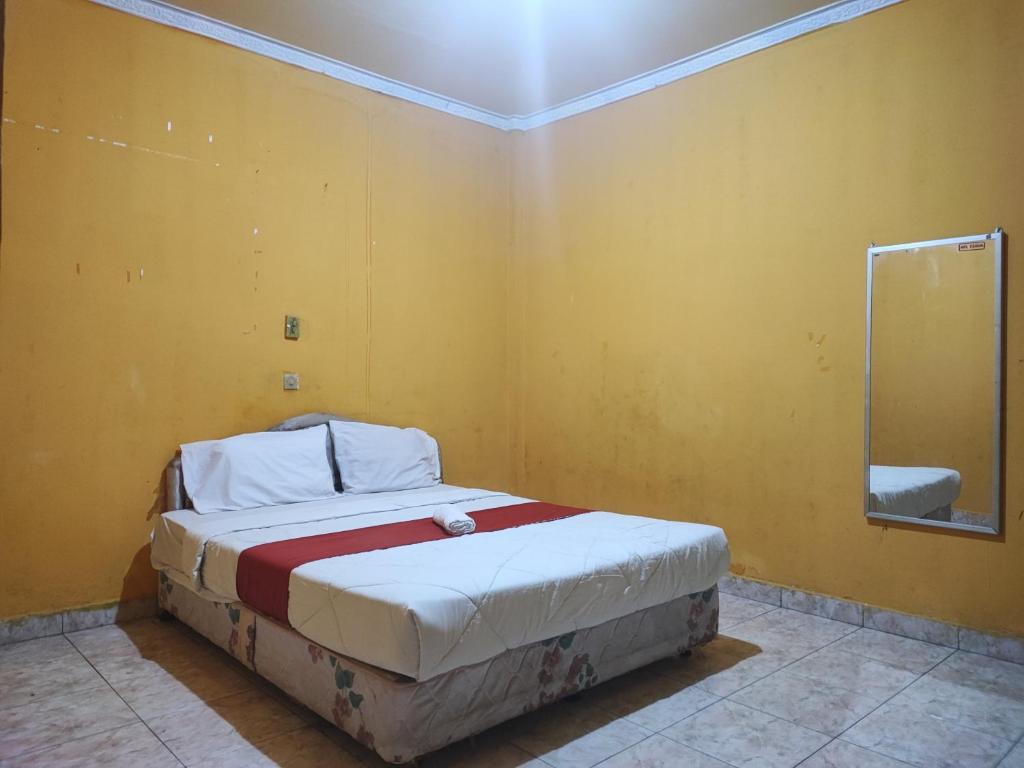 占碑市RedDoorz Syariah At Hotel Matahari 1 Jambi的卧室配有一张黄色墙壁上的床