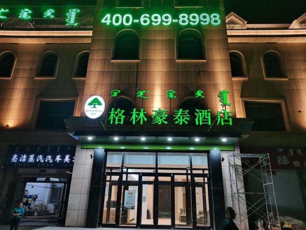 呼和浩特Green Tree Inn Huhhot Yuquan District South Campus of University of Inner Mongolia的前方有 ⁇ 虹灯标志的建筑